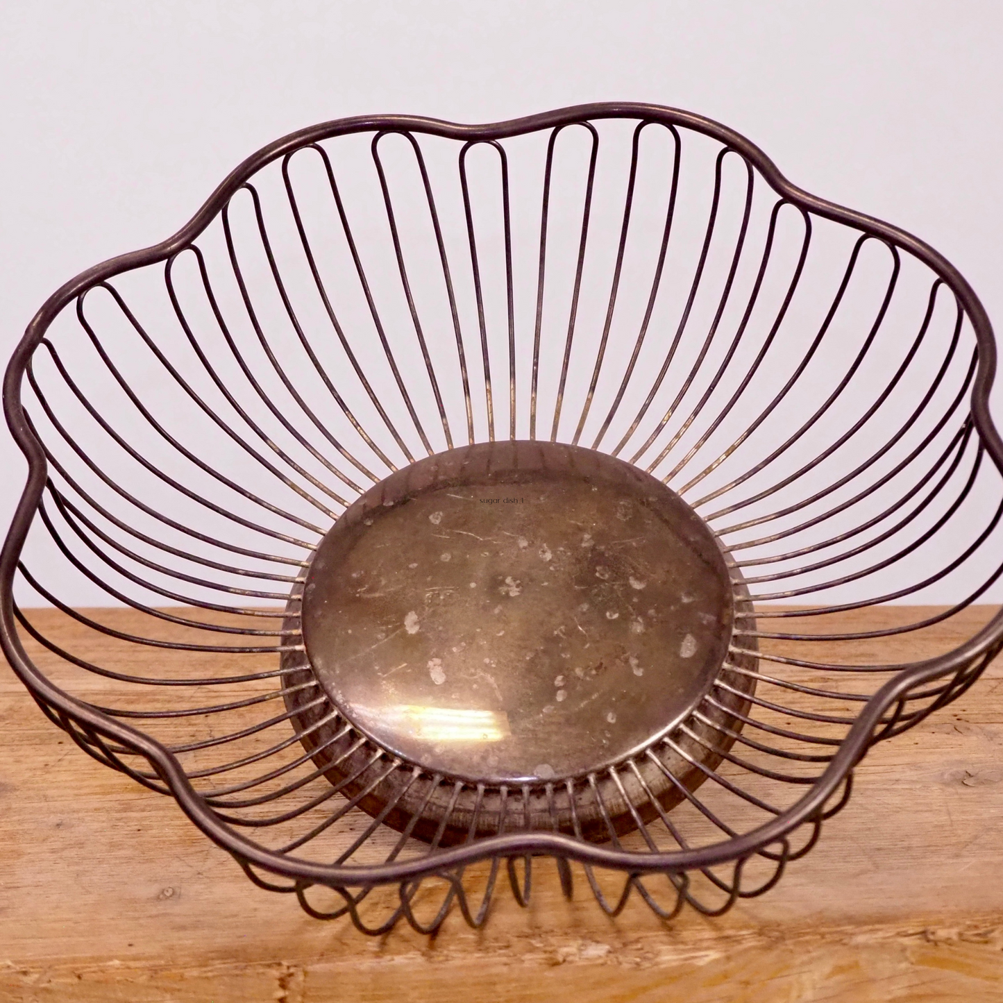 Silver patina scalloped fruit basket with base.