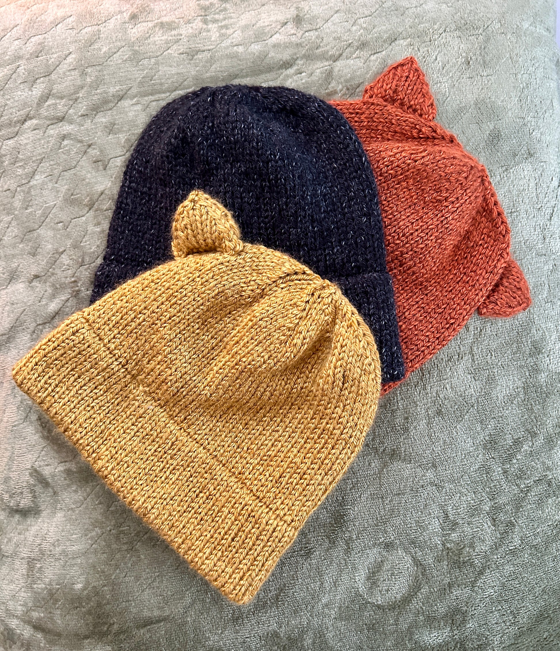 Three double brim knit beanie hats is assorted fall colors with adjustable knit cat ears