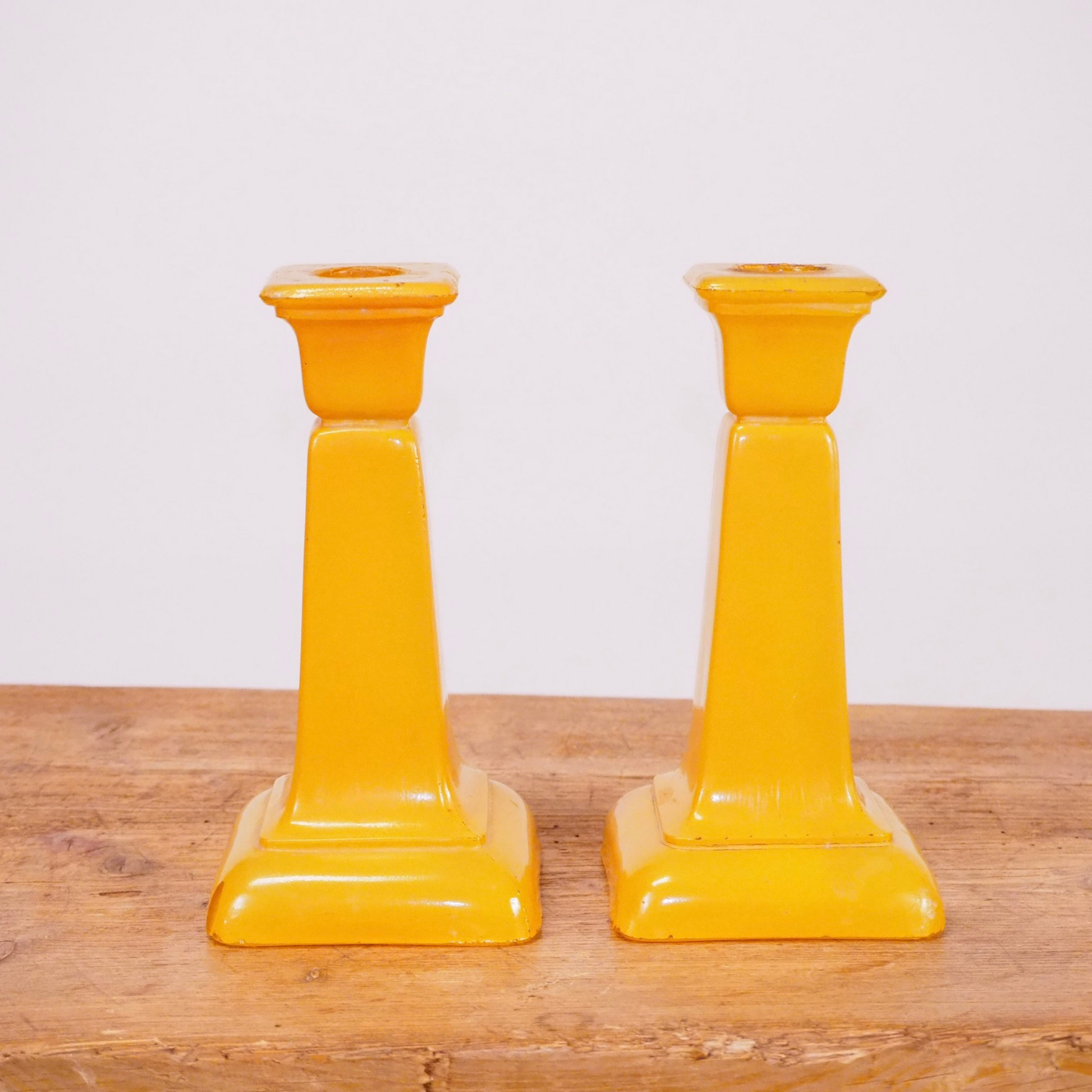 Pair of yellow frosted glass candlesticks with square base.