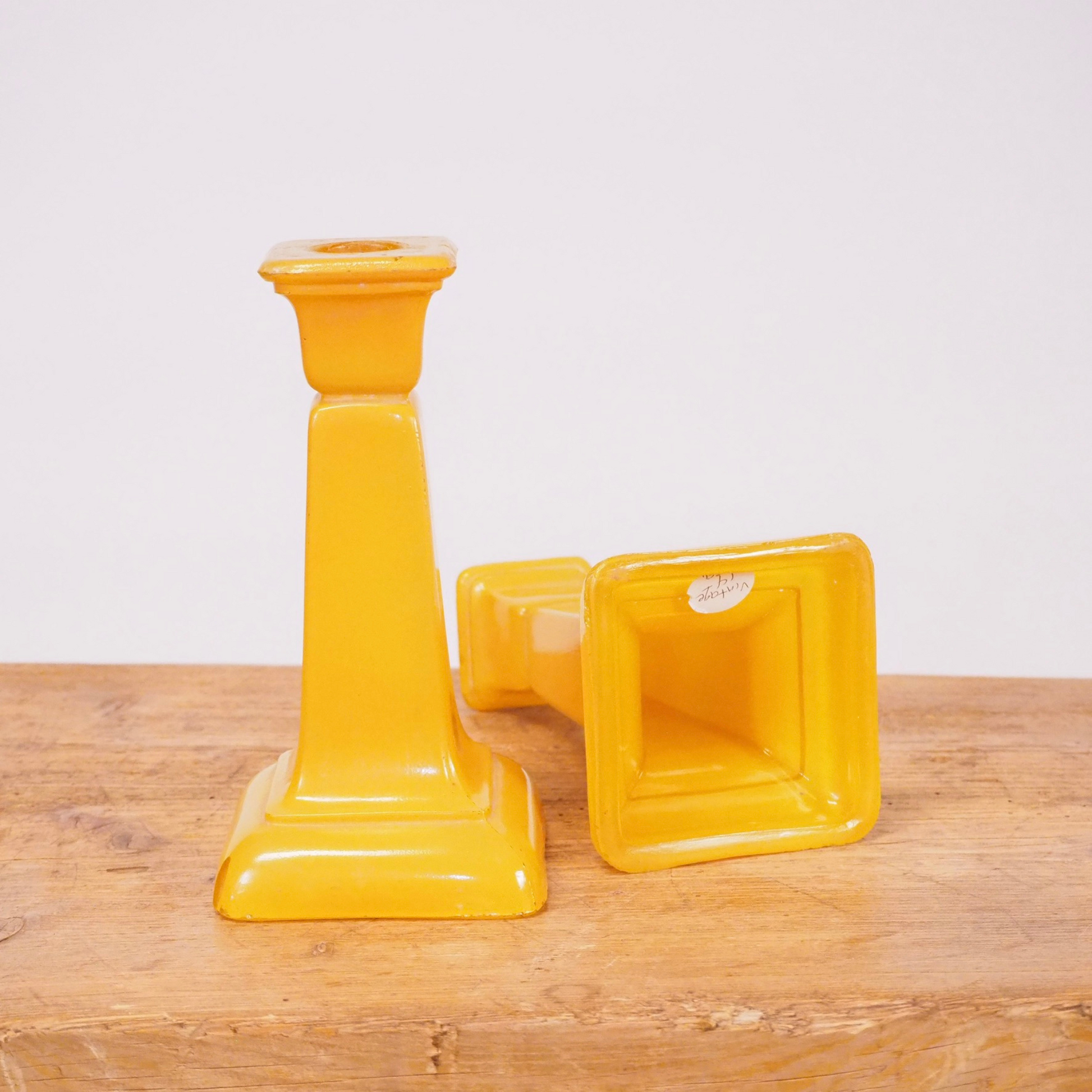 Pair of yellow frosted glass candlesticks with square base.