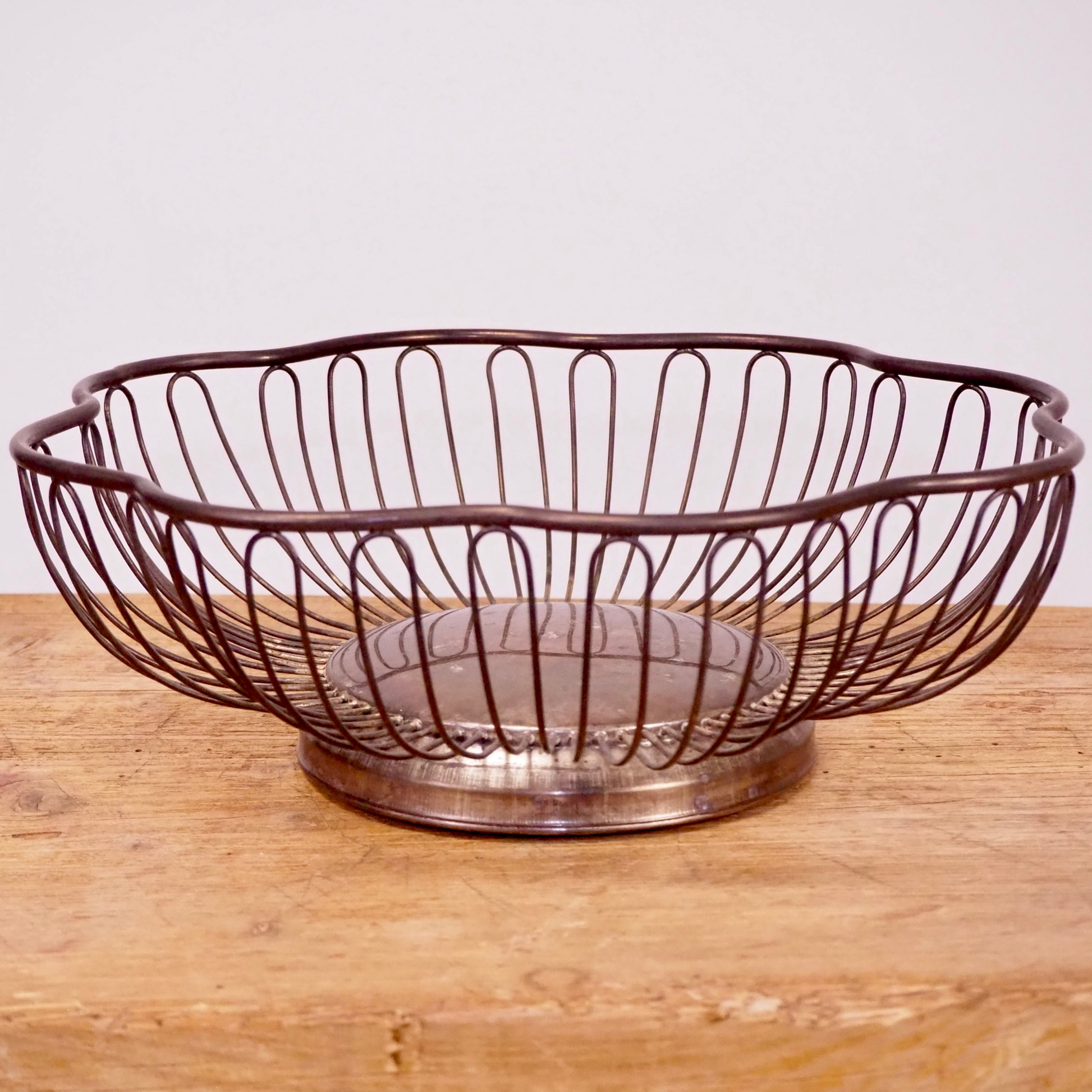 Silver patina scalloped fruit basket with base.